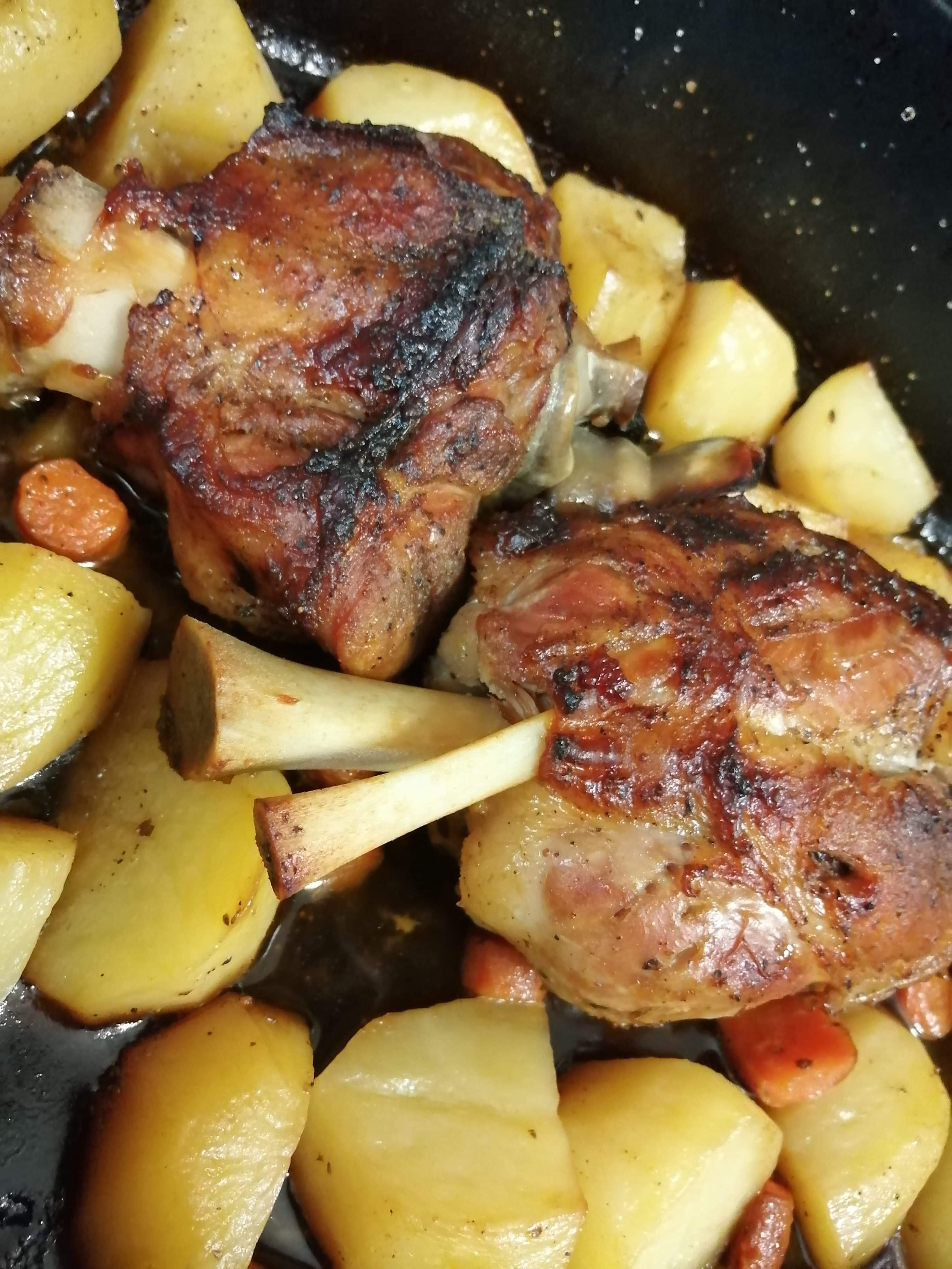 Χοιρινό κότσι στη γάστρα με πατάτες και καροτάκι